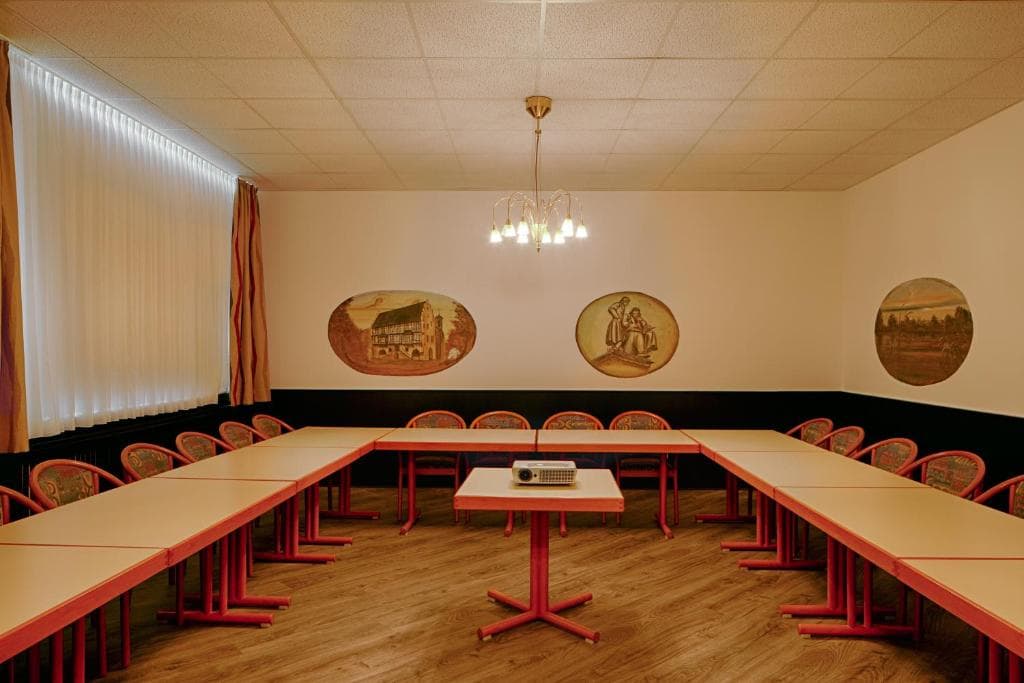 Meeting room set for a conference, with historic Hanau landscape paintings on the walls