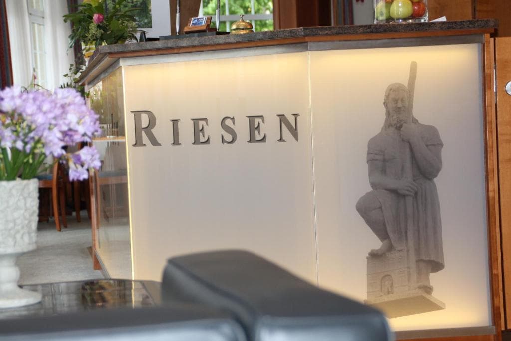 Reception desk with the hotel's backlit Riesen statue artwork