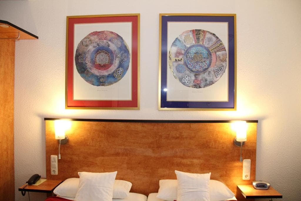 Quadruple room with two separate bed zones and artwork above the headboards
